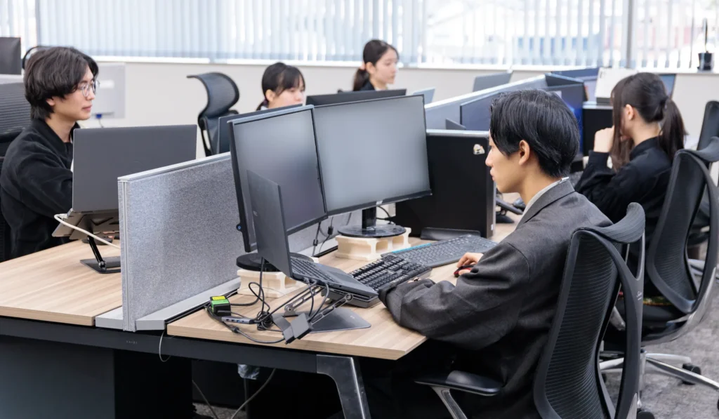 マルチモニター環境でシステム開発を行うワードシステムのエンジニア達