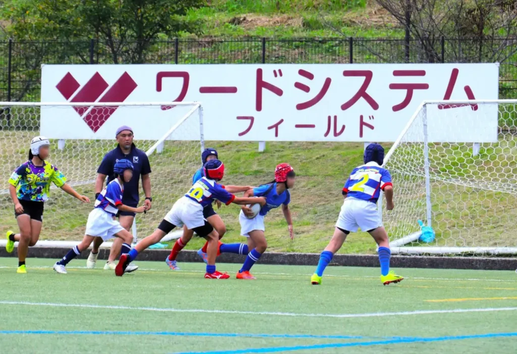 ワードシステムフィールドでラグビーをする子供たち
