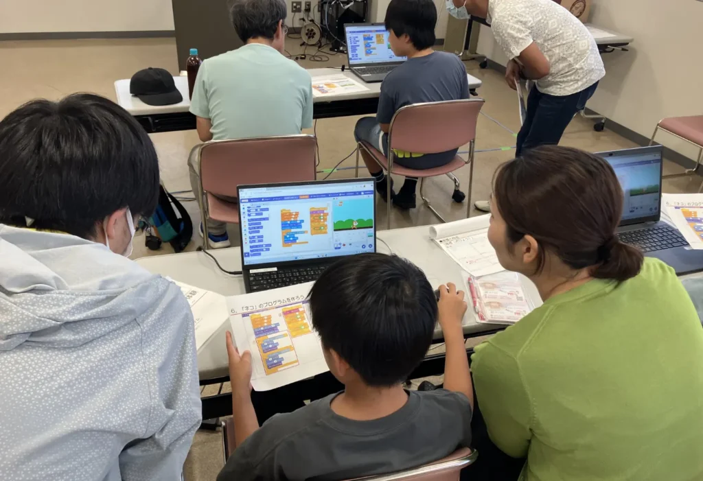 親子にパソコン操作を教えるワードシステムの社員